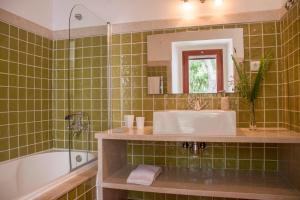 Reguengo GrandeCasal da Serrana的一间带水槽、浴缸和镜子的浴室