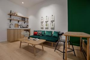 胡志明市Botanist Lab Minihotel by CIRCADIAN的客厅配有绿色沙发和桌子