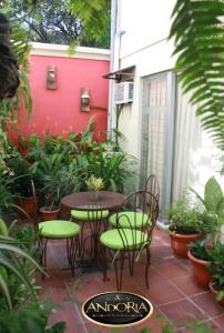 圣萨尔瓦多Hotel Andoria的一个带桌椅和红色墙壁的庭院