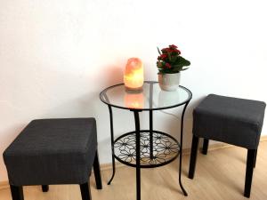 上特劳恩Haus Salzkristall的一张桌子,上面放着蜡烛,还有一株植物和两张凳子