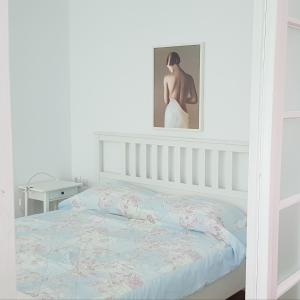 特尔戈维什泰Old Town Apartament的卧室配有一张床,墙上挂着一幅画