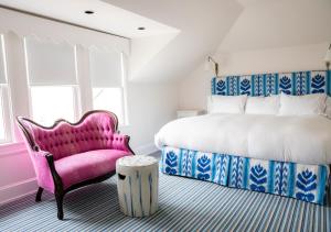 五月岬郡星辰宾馆的卧室配有粉红色的椅子和一张床