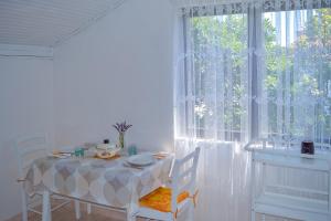 莫拉特岛Apartmani Mirko A1的一间带桌子和大窗户的用餐室