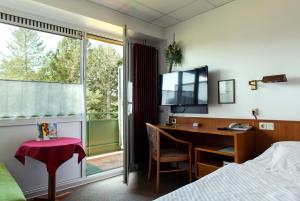 霍尔茨明登斯莱穆勒酒店的一间卧室配有书桌、床和窗户。