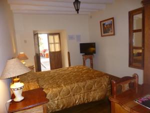 库斯科绿色酒店的一间卧室配有一张床、一张沙发和一台电视