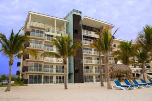查梅Playa Caracol Residences的棕榈树和椅子的海滩上酒店