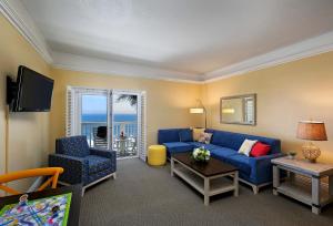 皮斯莫比奇皮斯莫灯塔套房酒店的客厅配有蓝色的沙发和椅子