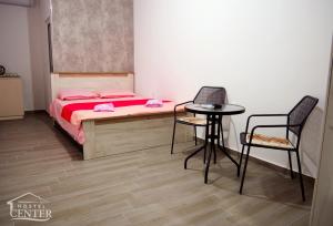乌尔齐尼Hostel Center的卧室配有一张床和一张桌子及椅子