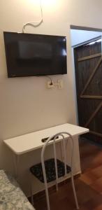 维多利亚Quarto particular em Vitória的一张白色的桌子,墙上有电视