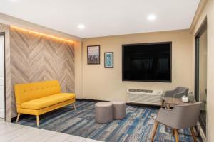 默塞德巴基特旅馆的一间设有黄色沙发和电视的等候室