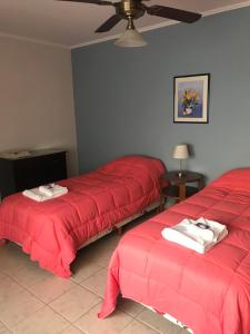 查斯科穆斯Departamento a 200 mts de la laguna的红色床单的客房内的两张床