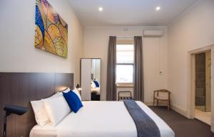 阿德莱德一英里终点汽车旅馆的一间卧室配有一张带蓝色枕头的大床