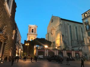 那不勒斯Palazzo Pignatelli的街道中间有钟楼建筑