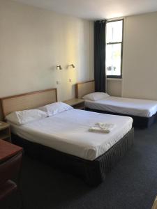 达尔文Darwin Poinciana Inn的酒店客房设有两张床和窗户。