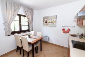 鲁容贝罗克Vila Helena - Apartmán Helena 15的厨房以及带木桌和椅子的用餐室。