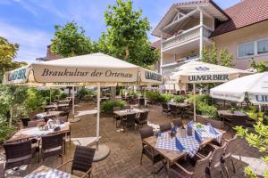杜尔巴赫林德杜尔巴赫酒店的餐厅设有带桌子和遮阳伞的户外庭院。
