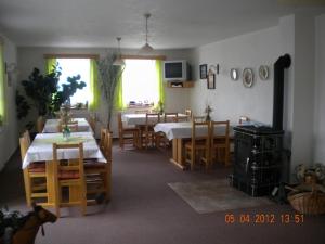 贝内茨科霍卢贝卡宾馆的一间带2张桌子和椅子的用餐室以及一间配有桌椅的房间