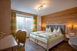 海因岑贝格Saibatenhof的一间卧室配有一张木墙床