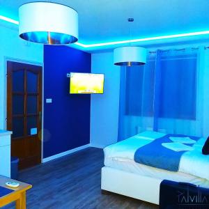 凯奇凯梅特Pál Villa - Premium Apartments - Kecskemét的蓝色卧室,配有床和两盏灯