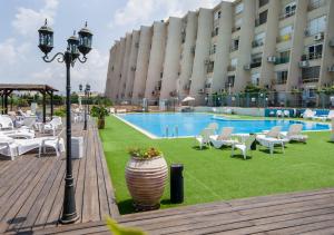 纳哈里亚Ha-aliya Sea View的一座带游泳池和椅子的酒店和一座建筑