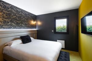 圣雅克德拉朗德Hotel L'Ortega Rennes Aéroport的卧室配有白色的床和窗户。