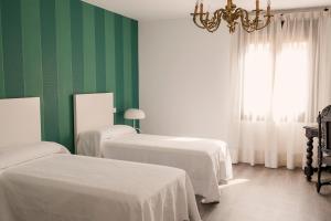 托莱多Domus Toledo的绿色和白色的客房设有两张床和吊灯。
