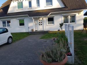 LütowFerienwohnung am Teich的前面有一辆汽车停放的白色房子