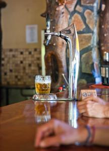 PalmPalmwag Lodge的一杯啤酒坐在一张桌子上,挂着水龙头