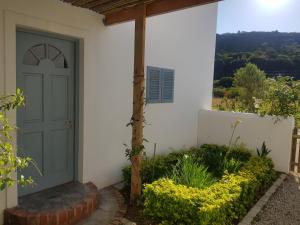 普利登堡湾Matjesfontein Estate Keurbooms Chalet的白色房子的前门,花朵花