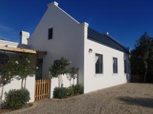 普利登堡湾Matjesfontein Estate Keurbooms Chalet的前面有栅栏的白色房子