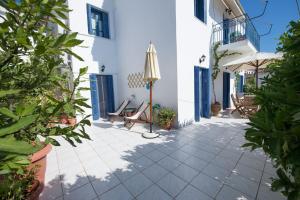 波罗斯Aquarella-stylish veranda apartment in centre of Poros town的一个带椅子和遮阳伞的庭院