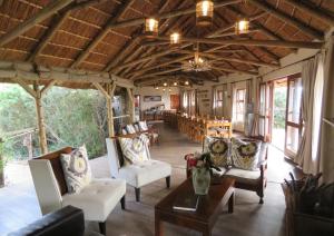 阿马卡拉保护区Woodbury Tented Camp – Amakhala Game Reserve的大楼内带桌椅的客厅