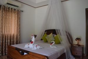 拉迪格岛绿竹小屋旅馆的一间卧室配有一张带两个天鹅的床