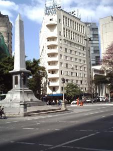贝洛奥里藏特巴西宫酒店的街道中间的纪念碑,有建筑物