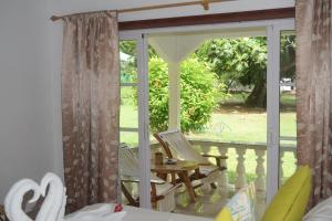 拉迪格岛绿竹小屋旅馆的客房设有带椅子和桌子的窗户。