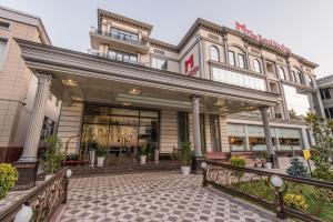 塔什干The Royal Mezbon Hotel & SPA的一座带庭院的建筑前的商店