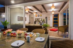 罗纳瓦拉EL Lodge by StayVista - Pool, lawn, and a charming gazebo for your perfect getaway的一间带桌椅的用餐室和一间客厅