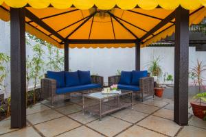 罗纳瓦拉EL Lodge by StayVista - Pool, lawn, and a charming gazebo for your perfect getaway的凉亭配有蓝色的椅子和桌子