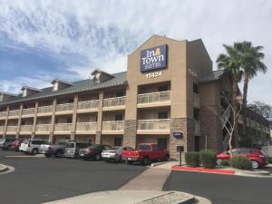 凤凰城InTown Suites Extended Stay Phoenix AZ - West的停车场内有车辆的旅馆