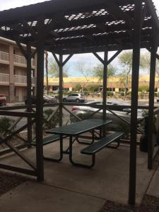 凤凰城InTown Suites Extended Stay Phoenix AZ - West的停车场内带野餐桌的野餐棚