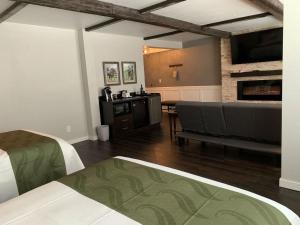 桑达斯基Cedar Stables Inn & Suites的带沙发和壁炉的客厅
