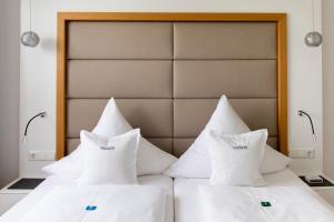 哈格瑙弗莱斯赫特酒店的客房内的两张床和白色枕头