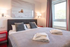加兹尤瑟多姆Appartement "Brillant" mit Penthouseflair - Oase am Haff的一间卧室配有一张大床和两条毛巾