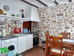 EstivellaRosita Casa Rural的厨房配有洗衣机和烘干机,位于石墙内