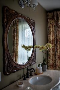 DorchesterMaplehurst Manor Bed and Breakfast的浴室水槽和墙上的大镜子