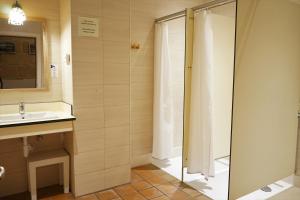 休达德亚Hostel Menorca的带淋浴和盥洗盆的浴室