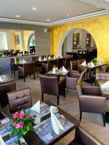 沃尔夫斯堡Boutique Hotel Goldene Henne的一间带桌椅的用餐室和一间餐厅