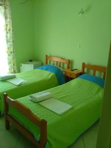 沃洛斯To Giouli的配有绿床单的客房内的两张床