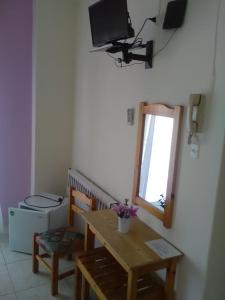 沃洛斯To Giouli的客厅配有桌子和墙上的电视