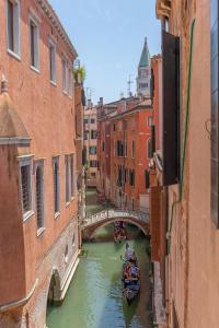 威尼斯Canal View San Marco Luxury Rooms的一条运河,在水中建桥和一条船